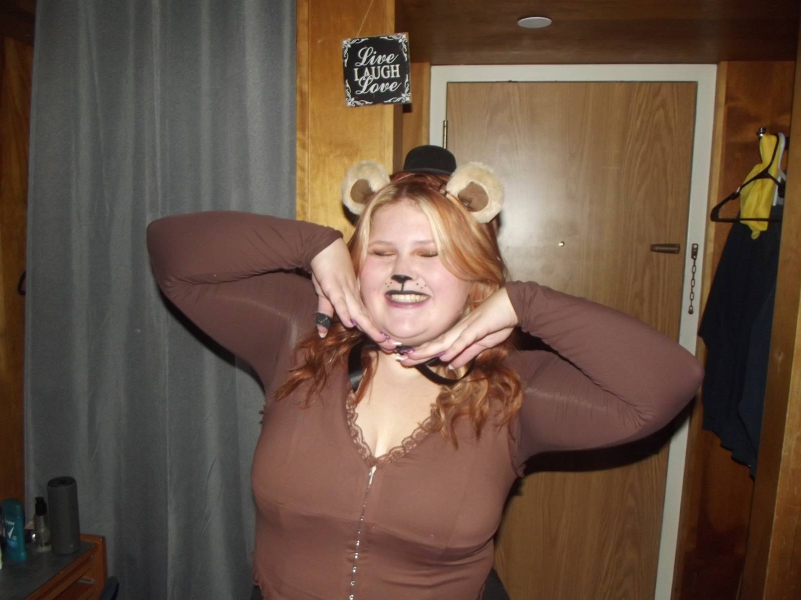 Person with a brown shirt with a painted cat face